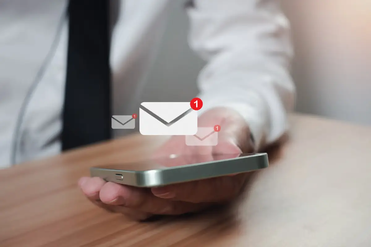 Emergency Response Close-up of a man in a suit holding a smartphone, with message notifications radiating outward.